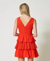 Vestido corto de algodón color rojo con bordado inglés, sin mangas, con escote en pico pronunciado, fruncido floral, volante de popelina en el bajo y cierre con cremallera lateral.