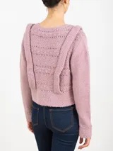 Sweater tejido color rosa con cuello redondo y mangas largas. Presenta apliques de tablas en los hombros y en el frente.