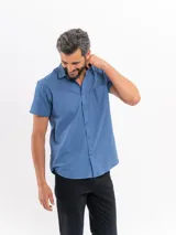 Camisa de manga corta color azul con efecto lino, corte clásico y bolsillo frontal en el pecho.