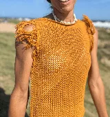 Musculosa tejida color violeta con diseño calado y flecos en los hombros.