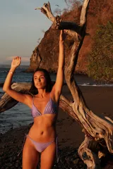 Conjunto de bikini color lavanda, compuesto por un top de estilo triangular con breteles regulables y una bombacha semivedetina con tiritas laterales ajustables.
