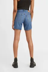 Short de jean azul oscuro, tiro medio, corte recto y largo hasta medio muslo. Presenta cierre de botones y cinco bolsillos.