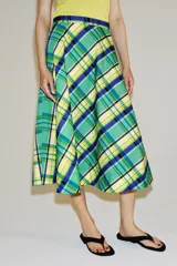 Falda midi de tiro medio marca ZWE Collection, confeccionada en hilatura de algodón con diseño de cuadros tipo tartán en tonos verdes, azules y amarillos. Tiene corte evasé y cierre lateral con cremallera oculta.