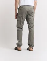 Pantalón de gabardina verde militar, corte cargo con bolsillos laterales con fuelle y tobillos ajustados con elástico.