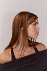 Remera deportiva de manga larga con diseño off-the-shoulder y escote doblado. Presenta frunces laterales y aberturas para pulgares en los puños, confeccionada en tejido de punto modal.