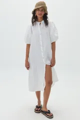 Vestido midi de lino color blanco, con mangas abullonadas hasta el codo, cuello mao y botonadura frontal con botones de nácar.