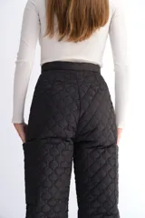 Pantalón negro de corte recto con diseño acolchado en forma de corazones.