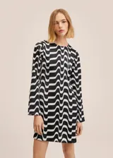 Vestido corto de manga larga con cuello redondo, confeccionado en tela satinada con estampado geométrico de ondas en blanco y negro.