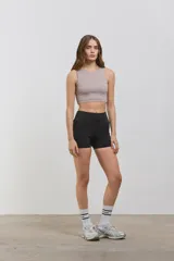 Minishort deportivo de calce ajustado con cintura alta y bolsillos laterales. Confeccionado en tejido elastizado de compresión media.