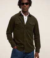 Camisa de hombre de corte regular confeccionada en terciopelo de algodón, con cuello clásico, cierre frontal de botones y dos bolsillos con solapa en el pecho.