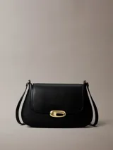 Cartera mediana con solapa Calvin Klein de color negro, confeccionada en poliuretano. Presenta diseño estructurado con cierre de broche a presión metálico dorado y correa ajustable.