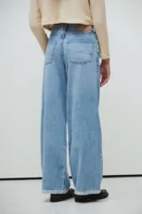 Pantalón de jean celeste, corte wide leg, tiro medio, con calce extra relaxed y piernas anchas.