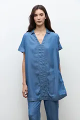 Túnica corta de lyocell color azul jean, con cuello en V, cuello camisero sutil, mangas cortas y costuras con pespuntes visibles en el frente.