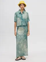 Falda larga tipo pareo con estampado efecto tie-dye en tonos azulados y verdosos. Presenta un diseño envolvente con tiras laterales ajustables que permiten regular el calce.