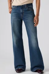 Jeans de denim azul de corte amplio y bota ancha, tiro medio, con efecto ligeramente lavado en las piernas y diseño clásico de cinco bolsillos.