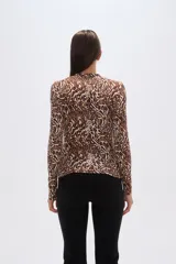 Remera de manga larga con cuello alto y estampado animal print en tonos marrones.