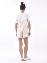 Mono corto negro de tirantes anchos ajustables con botones, escote cuadrado y corte holgado.