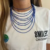 Collar de múltiples hilos de cuentas azules de diferentes tamaños.