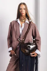 Cartera de cuero vacuno con estampado animal print, flecos largos de gamuza azul y asa con detalles de pasamanería.