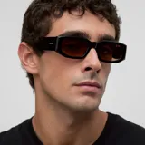 Lentes de sol con montura geométrica rectangular de color negro y lentes polarizadas en tono marrón. Presentan un diseño con detalles biselados en el marco.