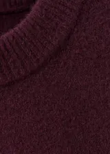 Sweater de punto medio color bordó, de silueta recta, manga larga y cuello redondo.