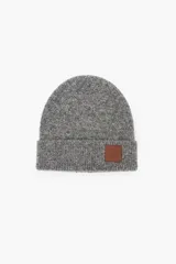 Gorro tejido de punto en color gris melange, con diseño de doblez en el borde y parche de cuero sintético con logo grabado.