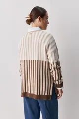Sweater de tejido jacquard con diseño de rayas verticales en tonos rojo, blanco y azul. Presenta cuello redondo, hombros caídos y puños en contraste de color azul.
