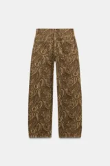 Jeans de tiro medio con diseño de perneras curvas y corte recto, confeccionados en denim con estampado paisley en tonos marrones y beige. Presentan diseño clásico de cinco bolsillos, trabillas para cinturón y cierre frontal con cremallera y botón metálico.