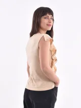 Remera de algodón color amarillo pastel, con cuello redondo y volados decorativos en los hombros con detalle de calado.