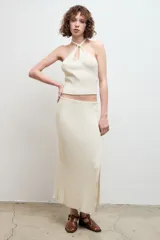 Falda midi color crudo, de punto canalé y corte recto, con abertura lateral.
