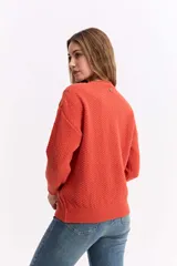 Buzo de punto color blanco, con cuello redondo y diseño de trama combinada con detalles trenzados. Presenta terminaciones tejidas en puños y ruedo.