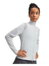 Buzo deportivo gris claro para mujer, con cierre frontal completo, cuello alto y mangas largas. Presenta paneles de malla calada en hombros, mangas y espalda para mayor transpirabilidad. Logo de la marca en el cuello.