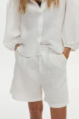 Short sastrero blanco de lino, con tiro alto, perneras anchas y pinzas en la parte delantera.