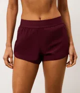 Short deportivo modelo runner con cintura elástica ancha y bajo redondeado. Presenta un diseño holgado y ligero, ideal para actividades físicas.