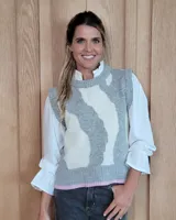 Chaleco tejido de punto con diseño abstracto en tonos gris y crema, con terminación en el ruedo en color rosado.