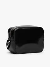 Cartera tipo bandolera de Tommy Jeans con acabado brillante y liso. Presenta un compartimento principal con cierre de cremallera y una insignia con el logo de la marca en la parte frontal. Incluye una correa ajustable.