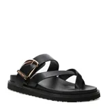 Sandalias planas Miss Carol modelo Solara de color negro, con diseño de tiras cruzadas y hebilla metálica decorativa dorada en el empeine.