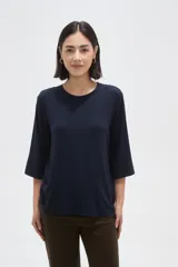 Remera de viscosa en color verde oliva, con cuello redondo y mangas 3/4. Presenta un diseño de tejido acanalado y corte holgado.