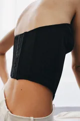 Top tipo corsé negro de Zara Woman Collection, confeccionado en hilatura con mezcla de algodón, con escote corazón y aros. Presenta bajo asimétrico y cierre en la espalda con ganchos metálicos.