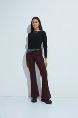 Pantalón de corte oxford, color negro, con ajuste en la cadera y pierna acampanada hacia el bajo. Presenta una silueta fluida y entallada.
