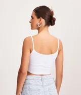 Musculosa tipo top cropped de breteles finos y escote redondo, confeccionada en tejido de punto de algodón con elastano.