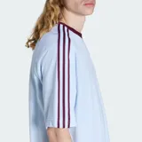 Remera Adidas Britcore Ringer de corte holgado, color celeste con detalles en bordó en el cuello redondo y las clásicas tres tiras en las mangas. Cuenta con el logo del Trifolio bordado en el pecho.