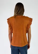 Remera de algodón negro con efecto acid wash, sin mangas y con volados fruncidos en los hombros.