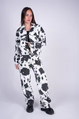 Pantalón jean de tiro alto en denim de algodón, con diseño de cuatro bolsillos y piernas amplias de corte recto, con estampado animal print tipo vaca en blanco y negro.