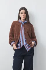 Cardigan de textura suave y efecto fluffy, color marrón, con silueta relajada, cuello redondo y cierre frontal con botones.