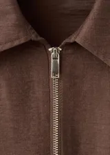 Blusa de mezcla de lino y viscosa color marrón, con diseño recto, cuello camisero, manga tres cuartos, bolsillo parche delantero, cierre de cremallera frontal y lazo ajustable en la cintura.