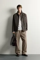 Sobrecamisa regular fit color marrón oscuro de algodón con estructura canvas, cuello solapa, manga larga, bolsillos frontales de parche y cierre de botonadura. Forro interior a cuadros en tonos marrón y beige.