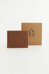 Billetera de cuero negra con pespuntes en color contrastante y logo de la marca grabado en bajo relieve. Interior con múltiples compartimentos y tarjetero extraíble.