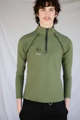 Remera térmica verde militar de manga larga, confeccionada en jersey de algodón grueso con vivos en contraste y logo bordado. Cierre frontal con cremallera YKK.