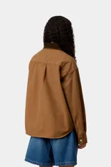 Chaqueta de lona de algodón marrón de peso medio, con cuello de pana y dos bolsillos en el pecho con botones. Incluye cierre frontal con botones a presión y etiqueta con el logo de la marca en el bolsillo izquierdo.